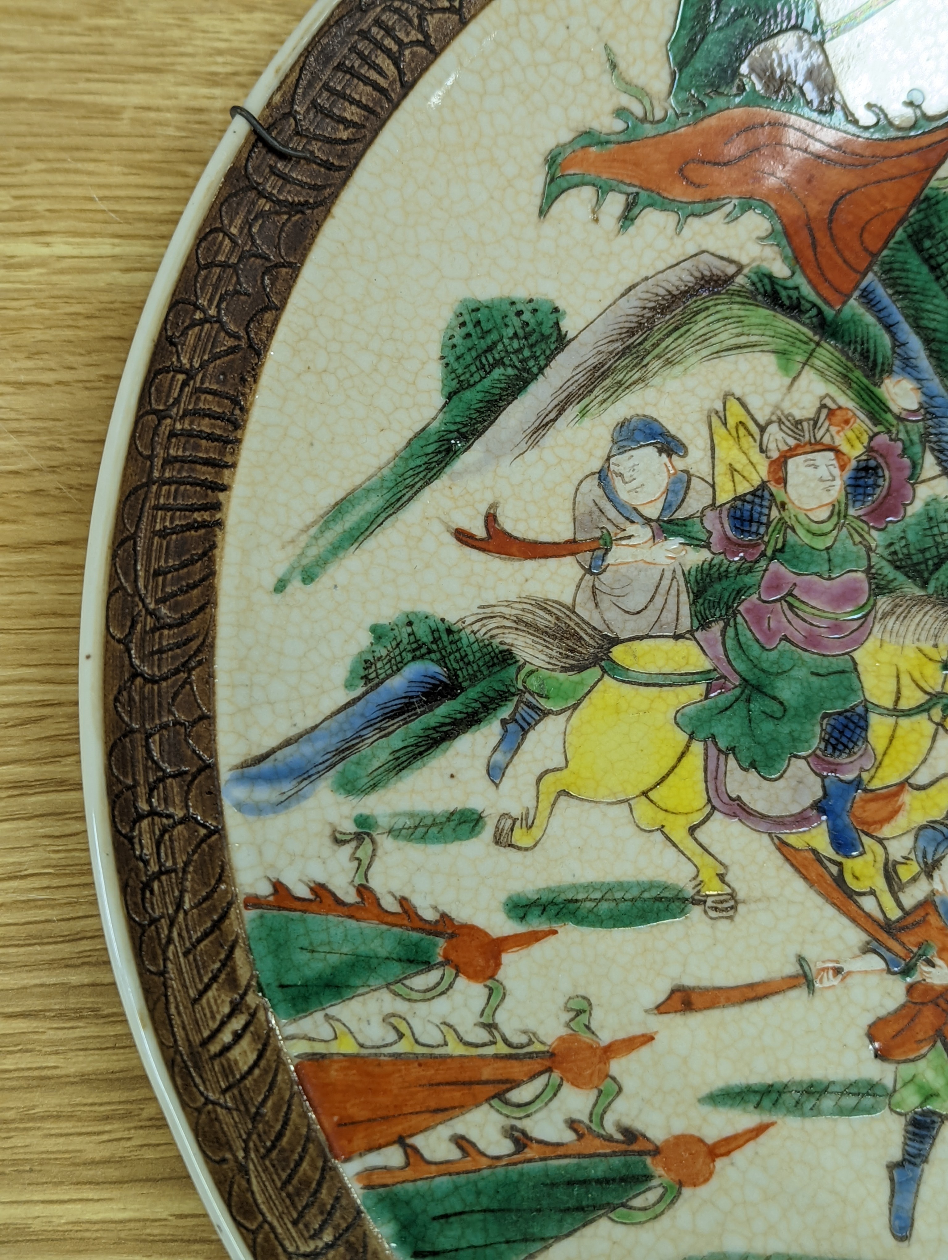 A Chinese crackle glaze dish, early 20th century, depicting a battle scene 33cm